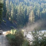 Larry's car raised a cloud of dust as he decended a grade.